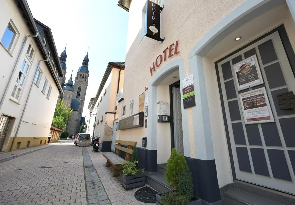 Eingang des Hotel Alt Speyer in der Großen Gailergasse, im Hintergrund die Türme der Kirche St. Joseph